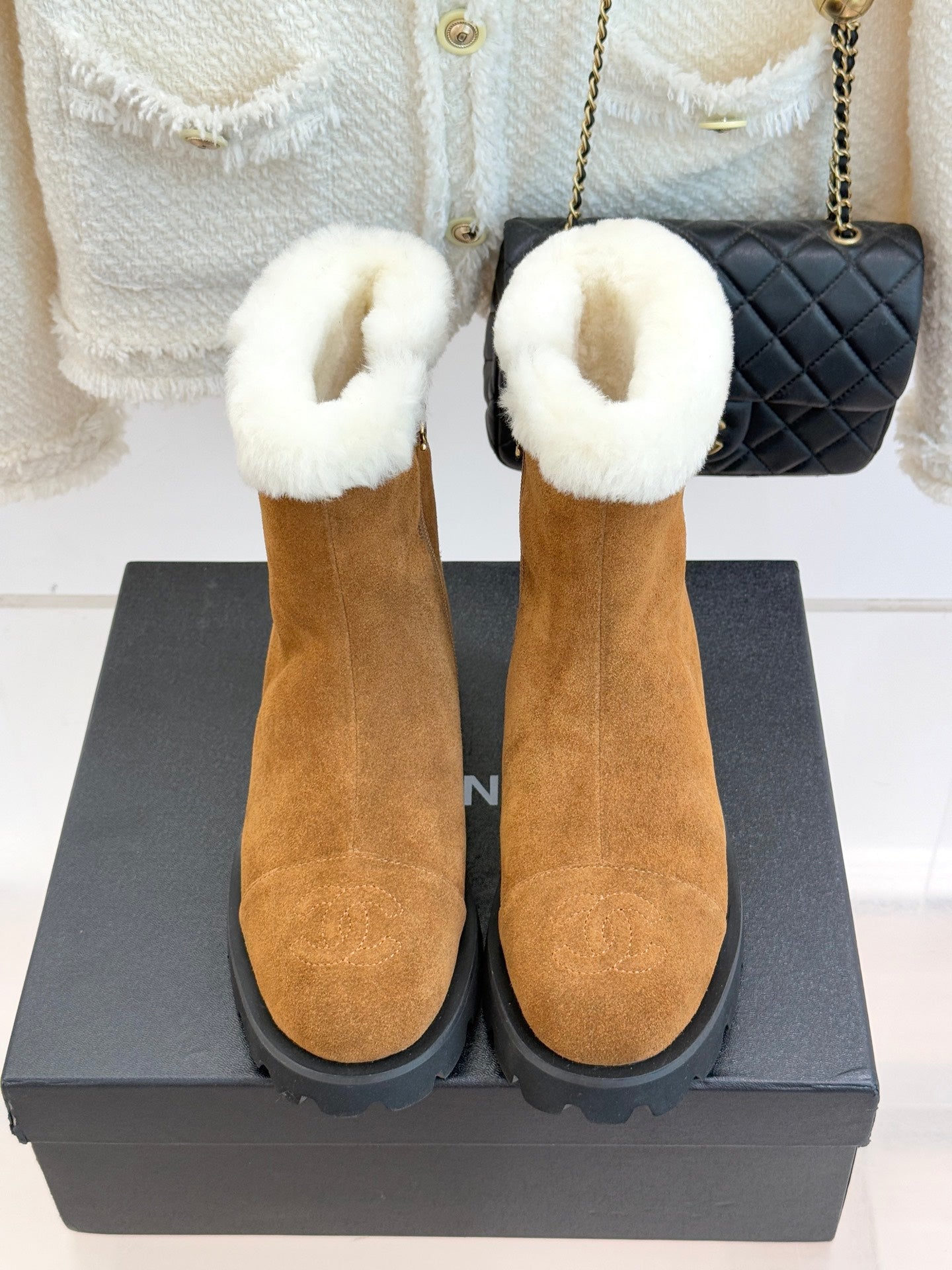 Tan suede ankle boots with white faux-fur cuffs and black lug heel sole.