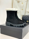 Black suede ankle boots with white shearling cuff and chunky gray lug sole