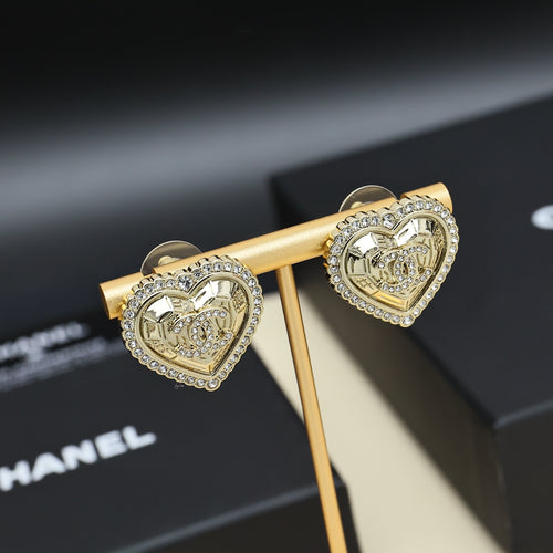 Gold-tone heart stud earrings on a gold holder with rhinestone outer trim