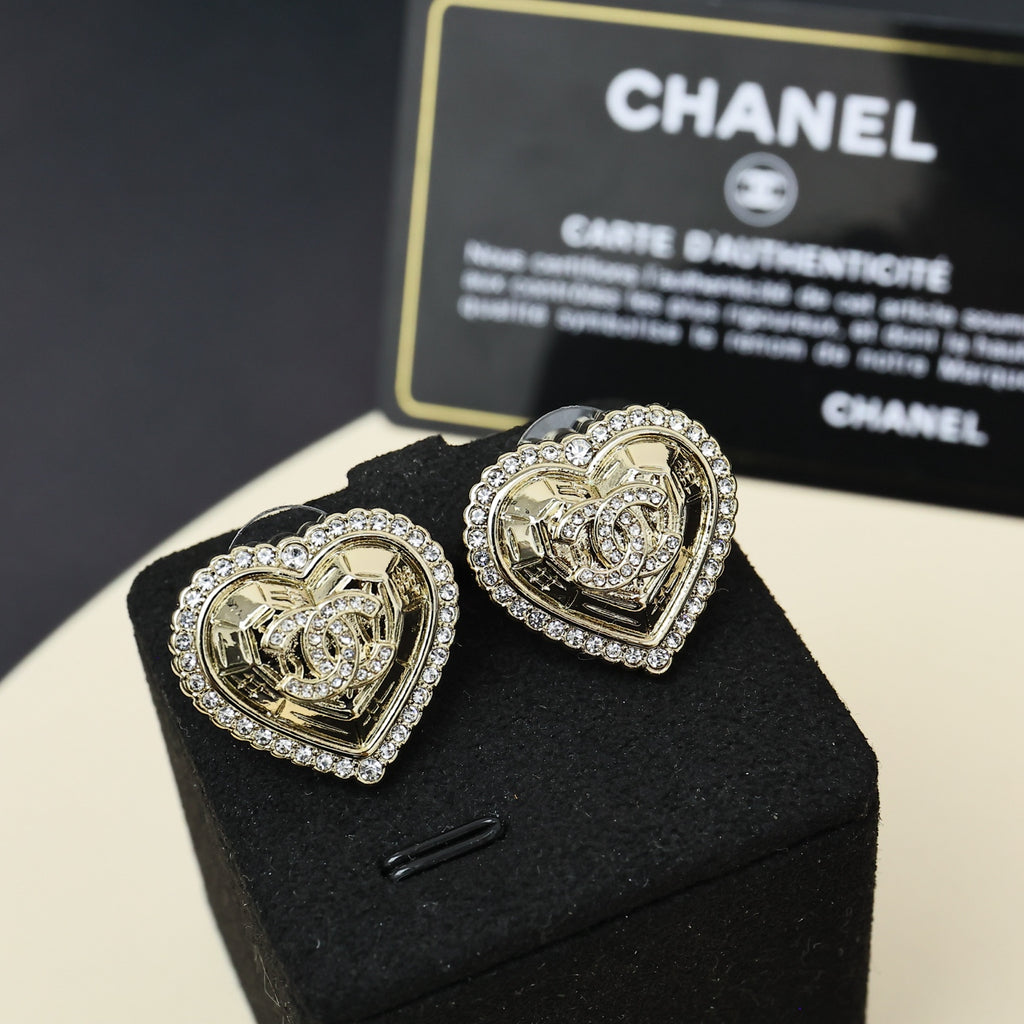 Gold-tone heart stud earrings with rhinestone halo and engraved center crest