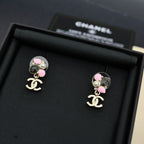 Chanel drop earrings with pink beads, pearls, and black oval charm with logo