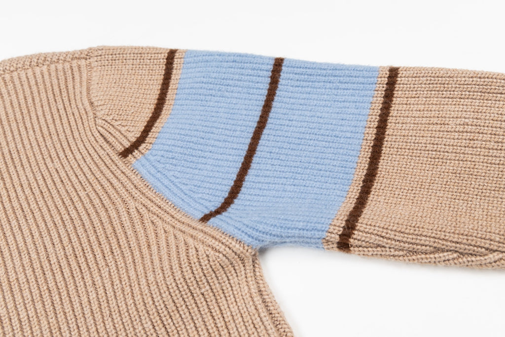Beige knit sweater with blue shoulder stripe panel and brown edging