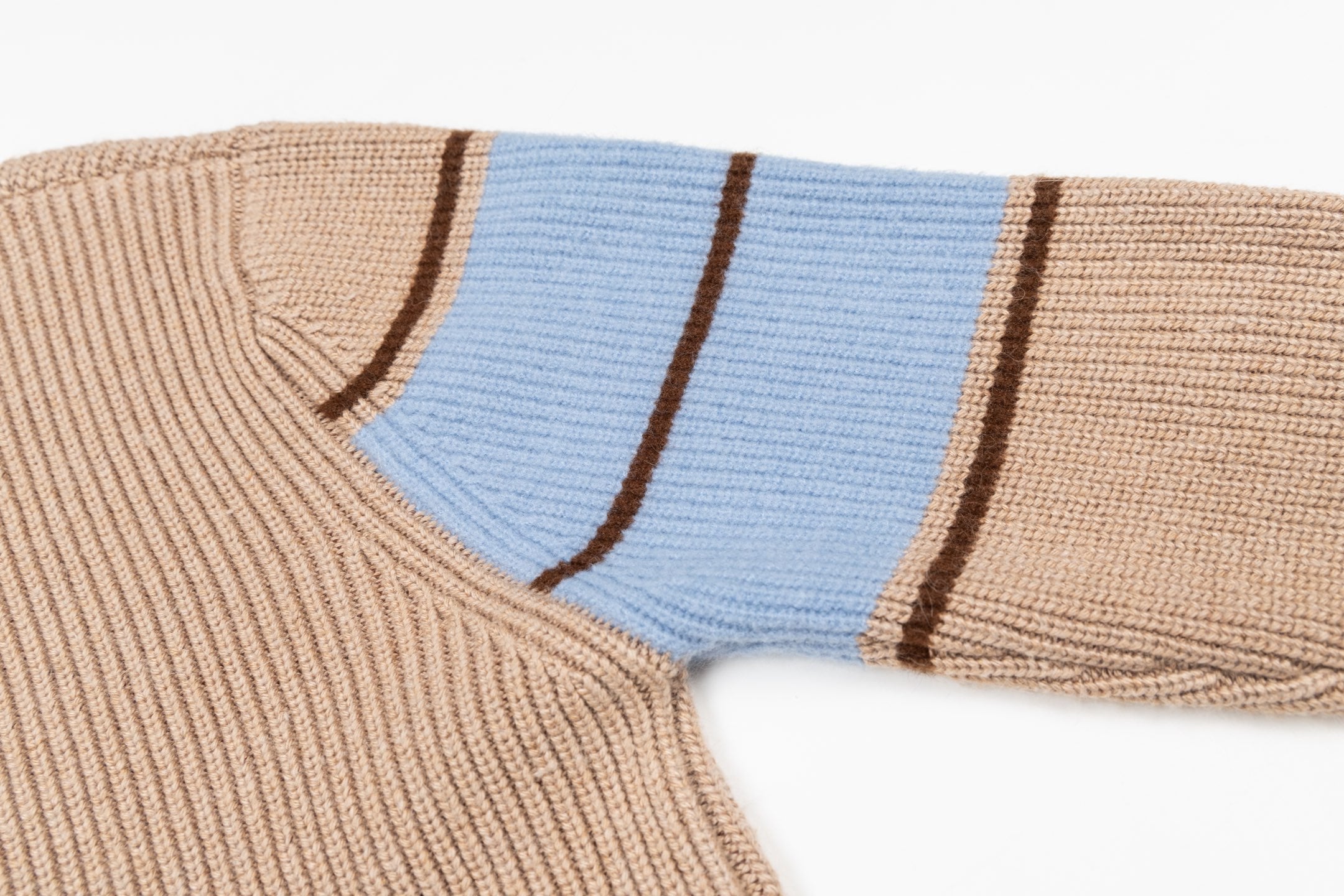 Beige knit sweater with blue shoulder stripe panel and brown edging