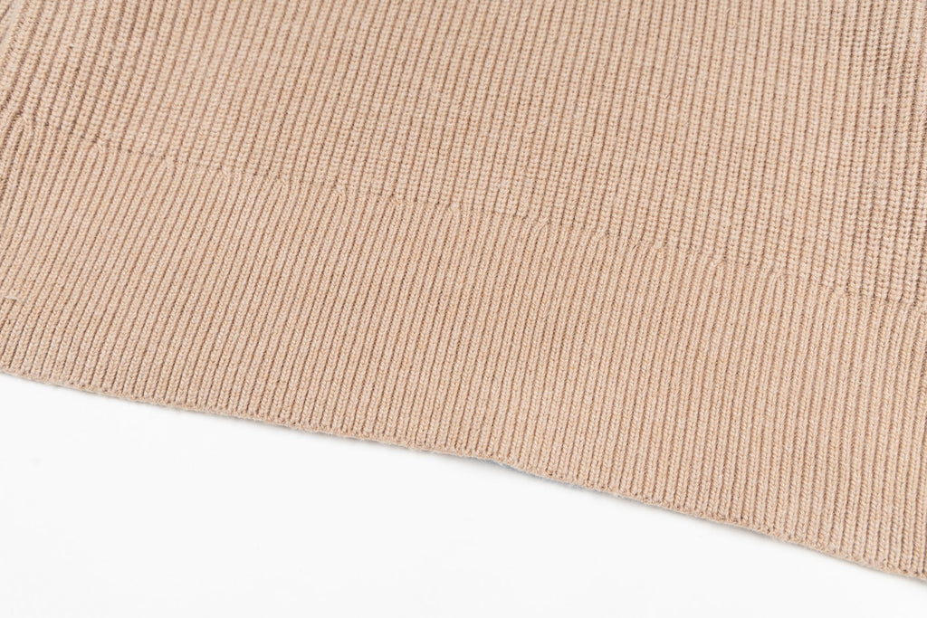 Beige ribbed knit sweater hem with fine stitch texture