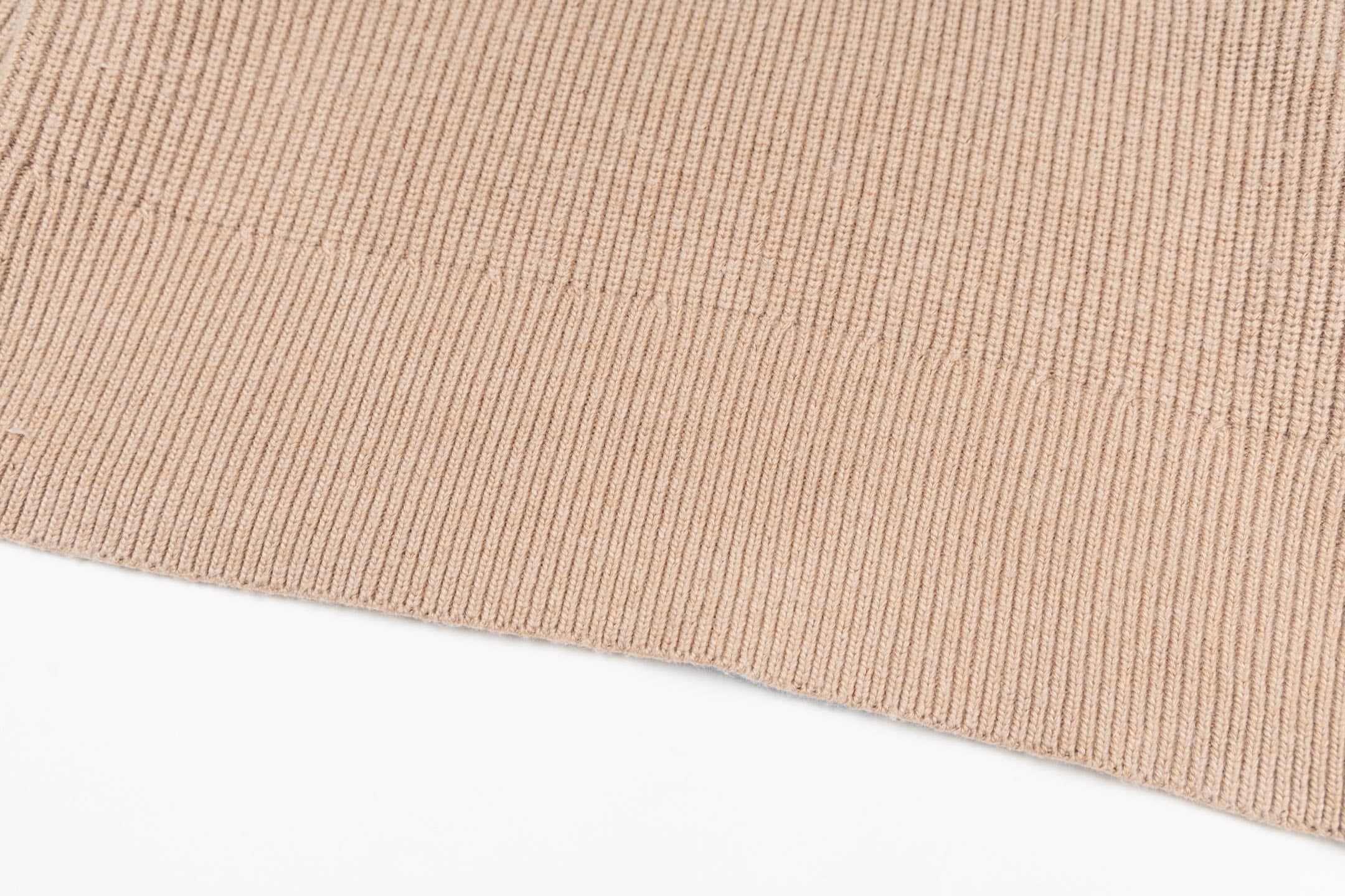 Beige ribbed knit sweater hem with fine stitch texture