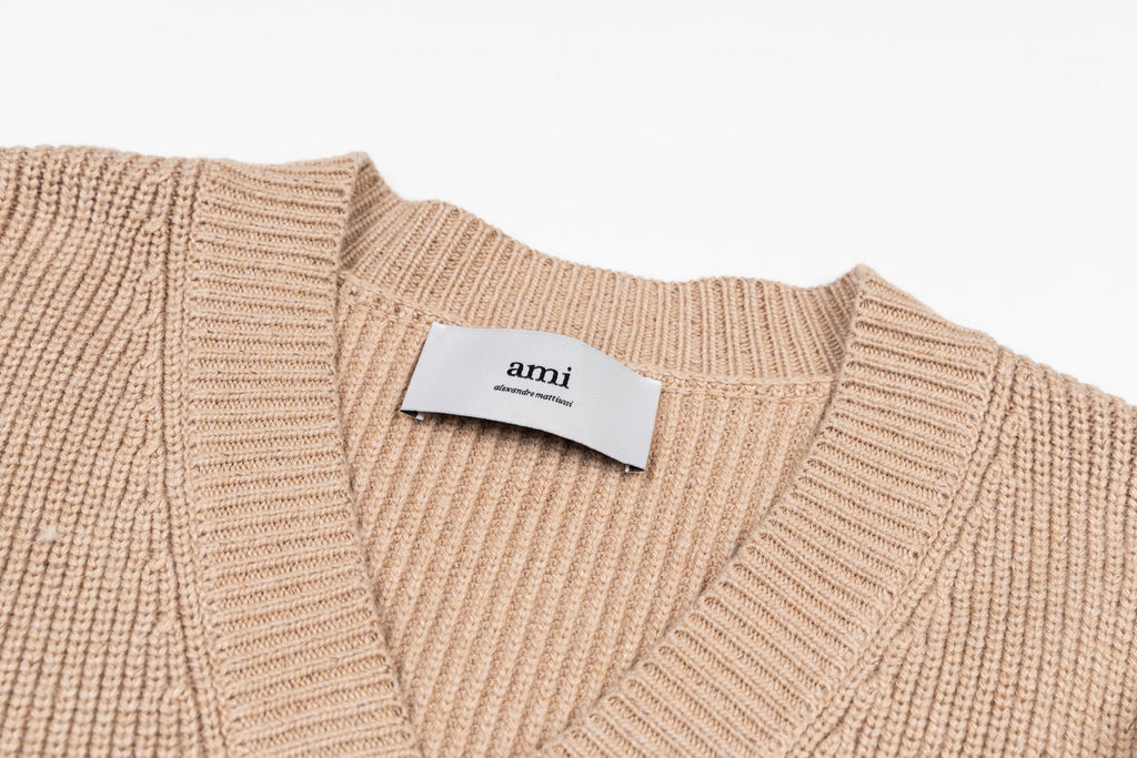 Beige knit V-neck sweater with ribbed collar and Ami label at neckline