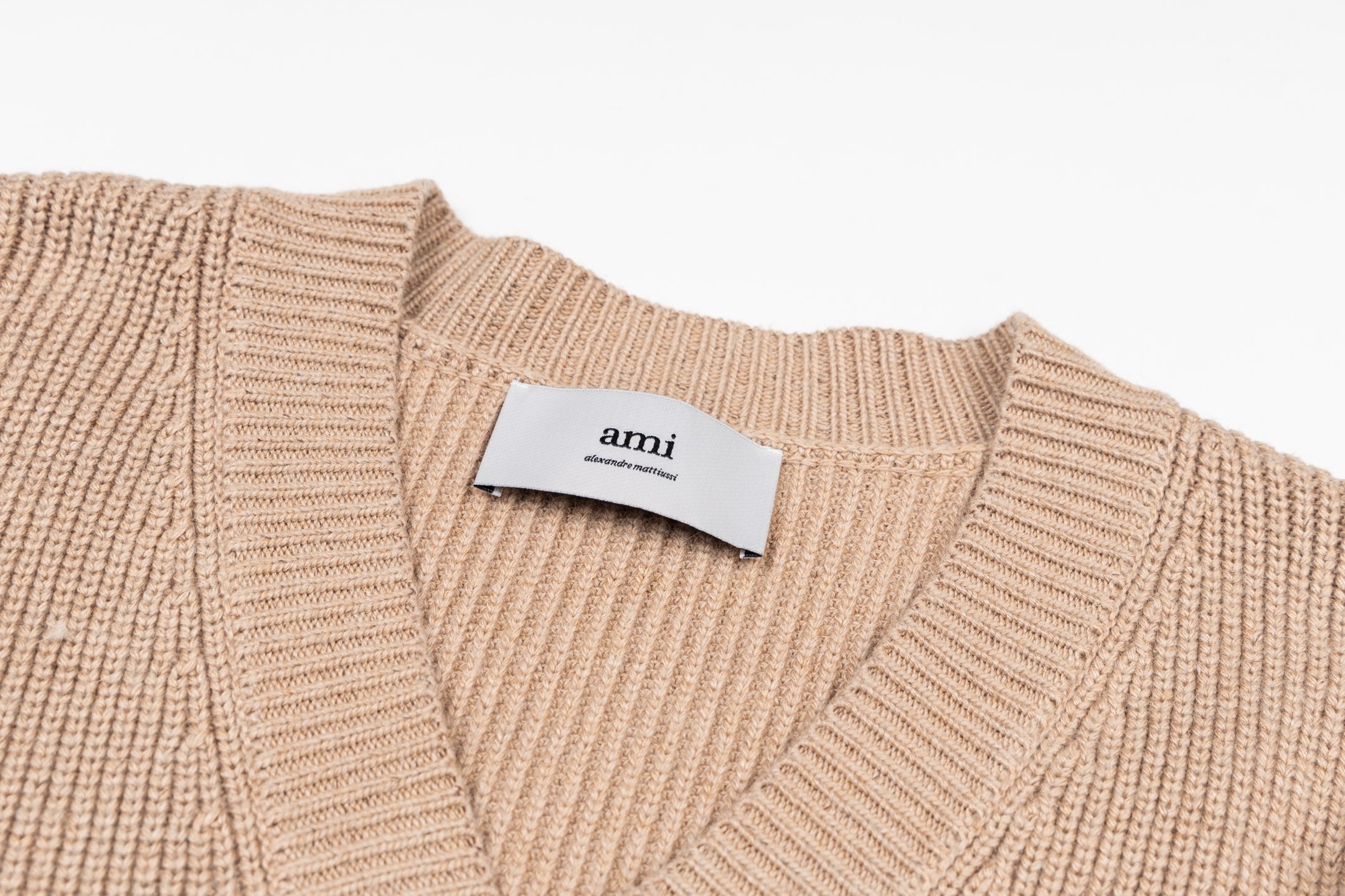 Beige knit V-neck sweater with ribbed collar and Ami label at neckline