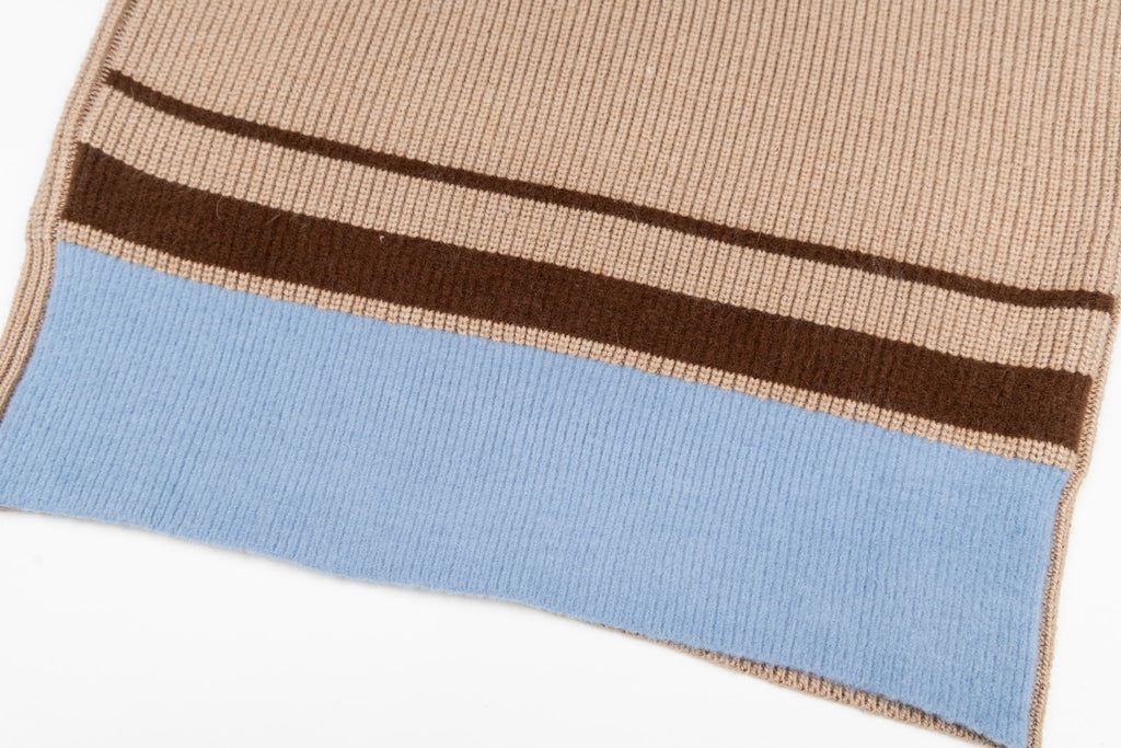 Beige knit sweater hem with dark brown and blue striped band