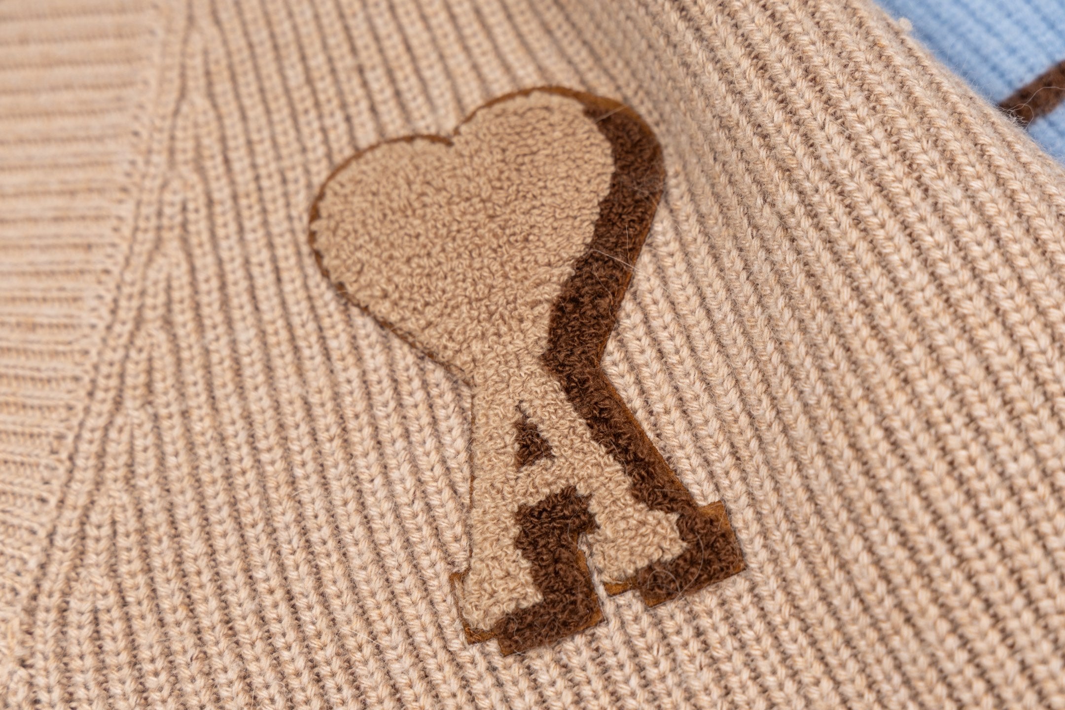Beige knit sweater with brown heart applique and stitched monogram