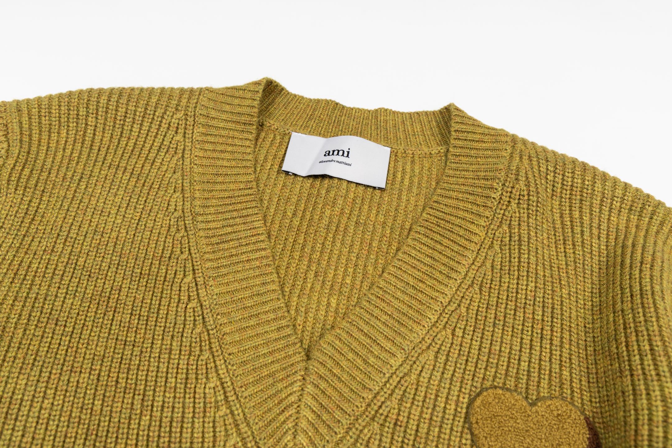 V-neck knit sweater close-up with ribbed trim and A heart applique