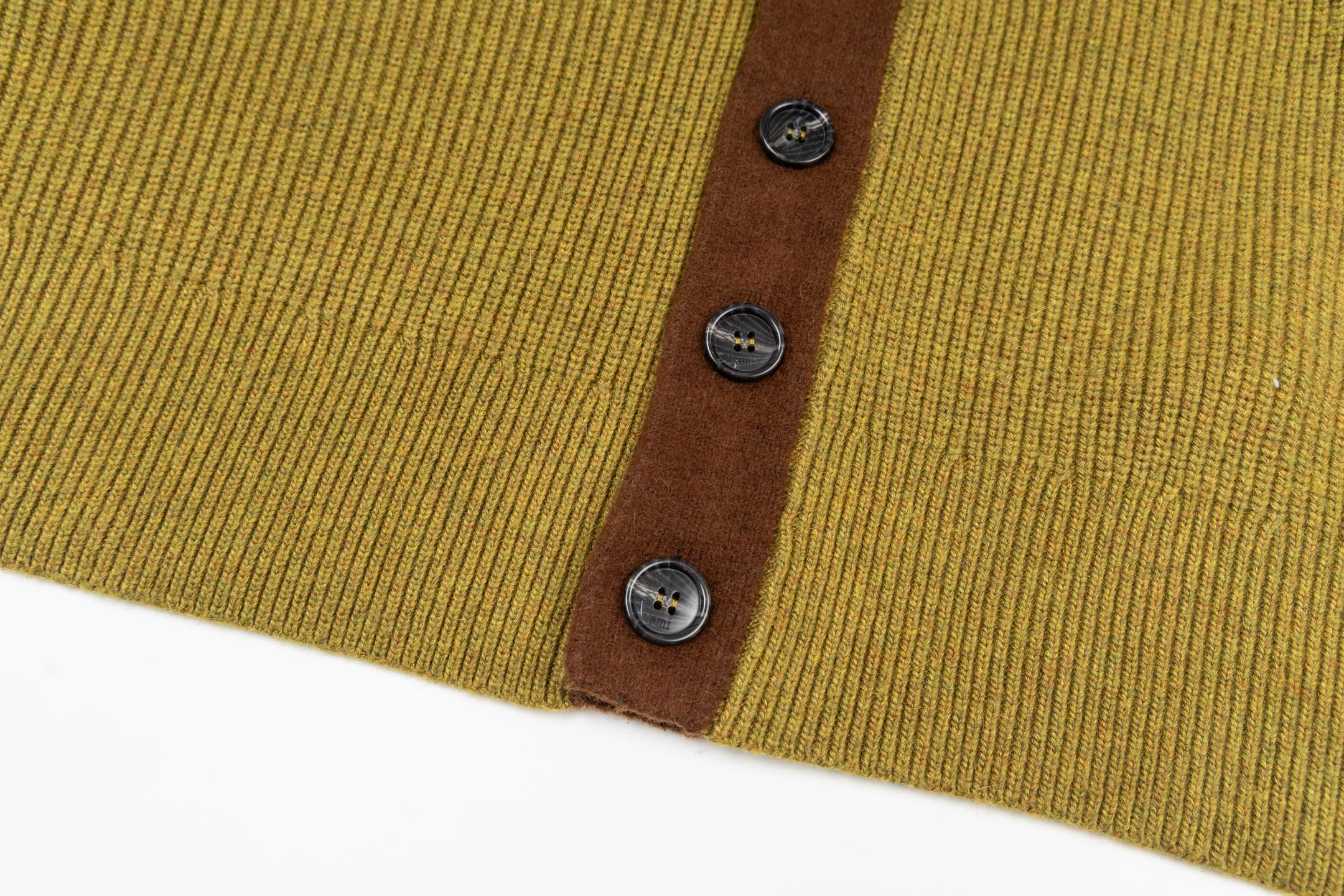 Olive knit hem with brown placket and three dark metal buttons