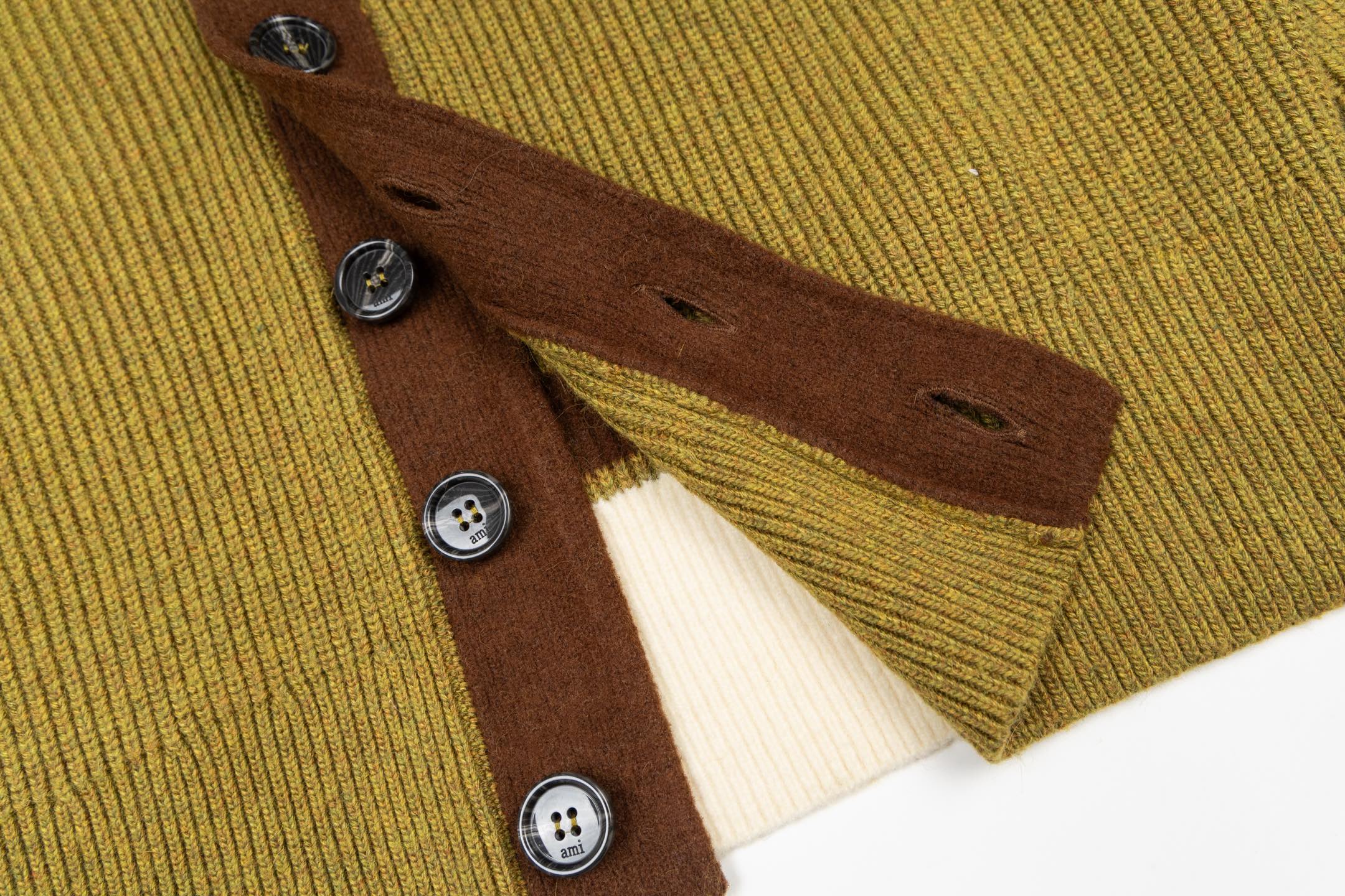 Brown front placket with dark metal buttons and olive ribbed knit collar