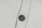 Light gray knit cardigan with round dark button on front placket