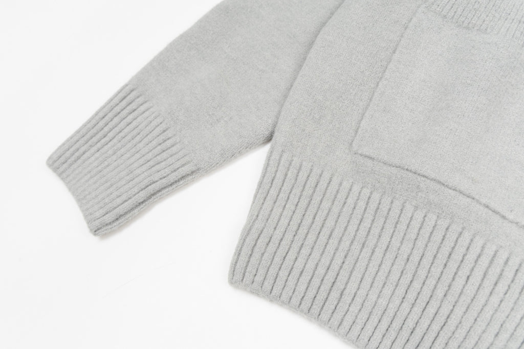 Light gray knit cardigan sleeve and ribbed cuff with sweater hem