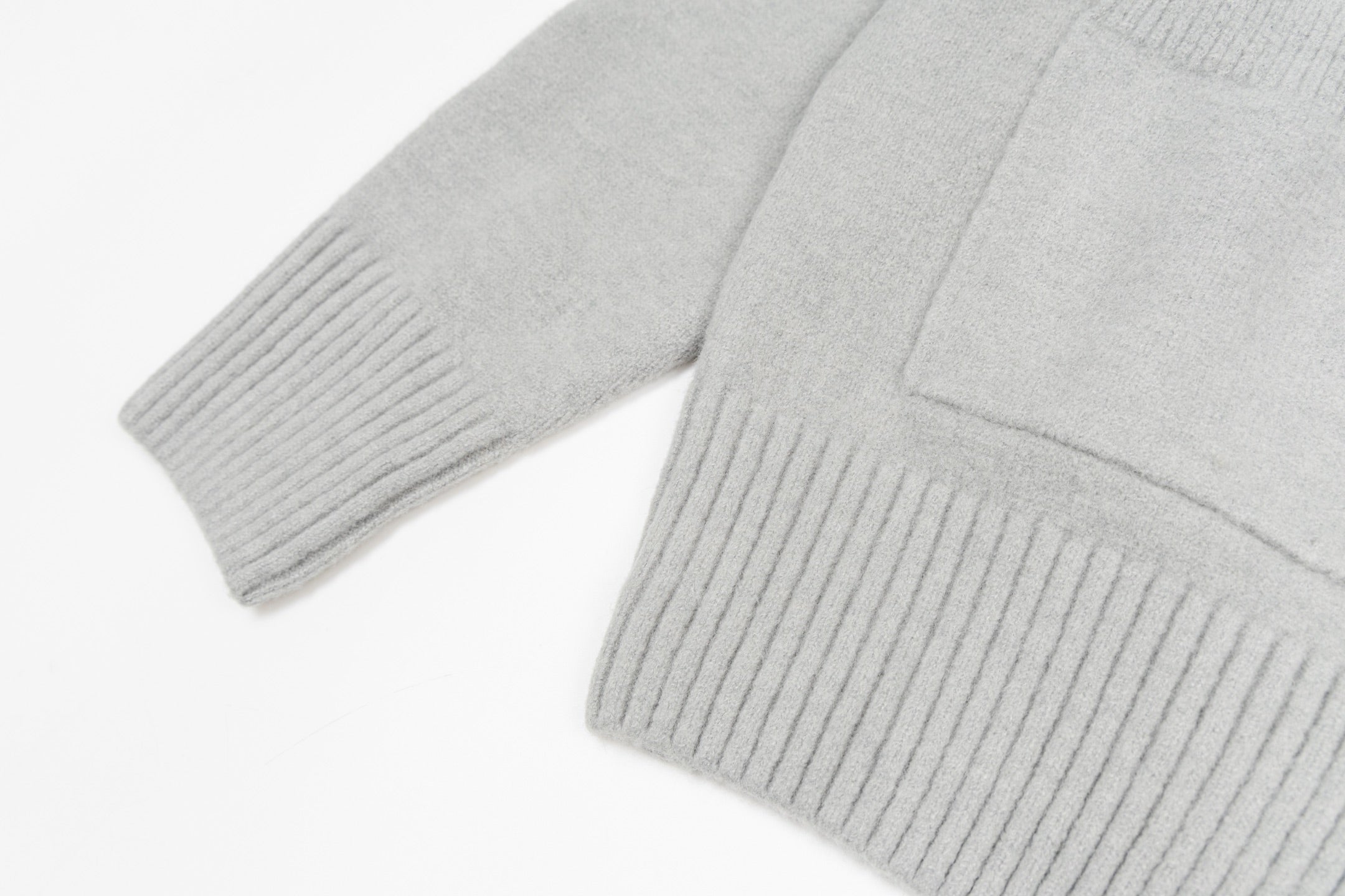 Light gray knit cardigan sleeve and ribbed cuff with sweater hem