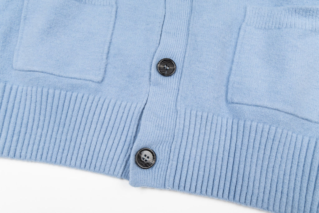 Amiri light blue knit cardigan front hem with buttons and patch pockets close-up