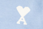Amiri light blue sweater with white heart-and-X emblem