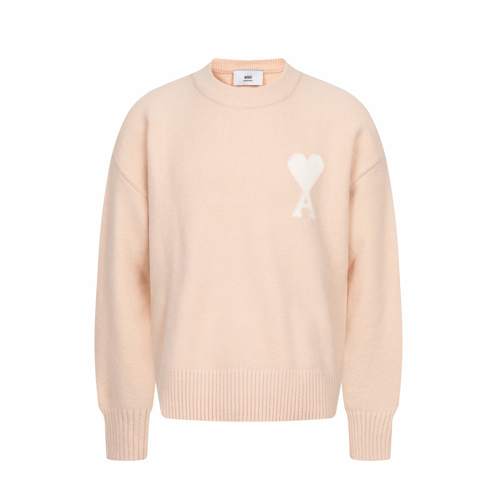 Light pink crewneck sweater with ribbed cuffs and hem, featuring a white heart logo