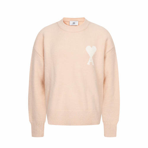 Light pink crewneck sweater with ribbed cuffs and hem, featuring a white heart logo