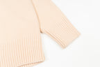 Light pink sweater cuff with ribbed knit texture at the sleeve hem