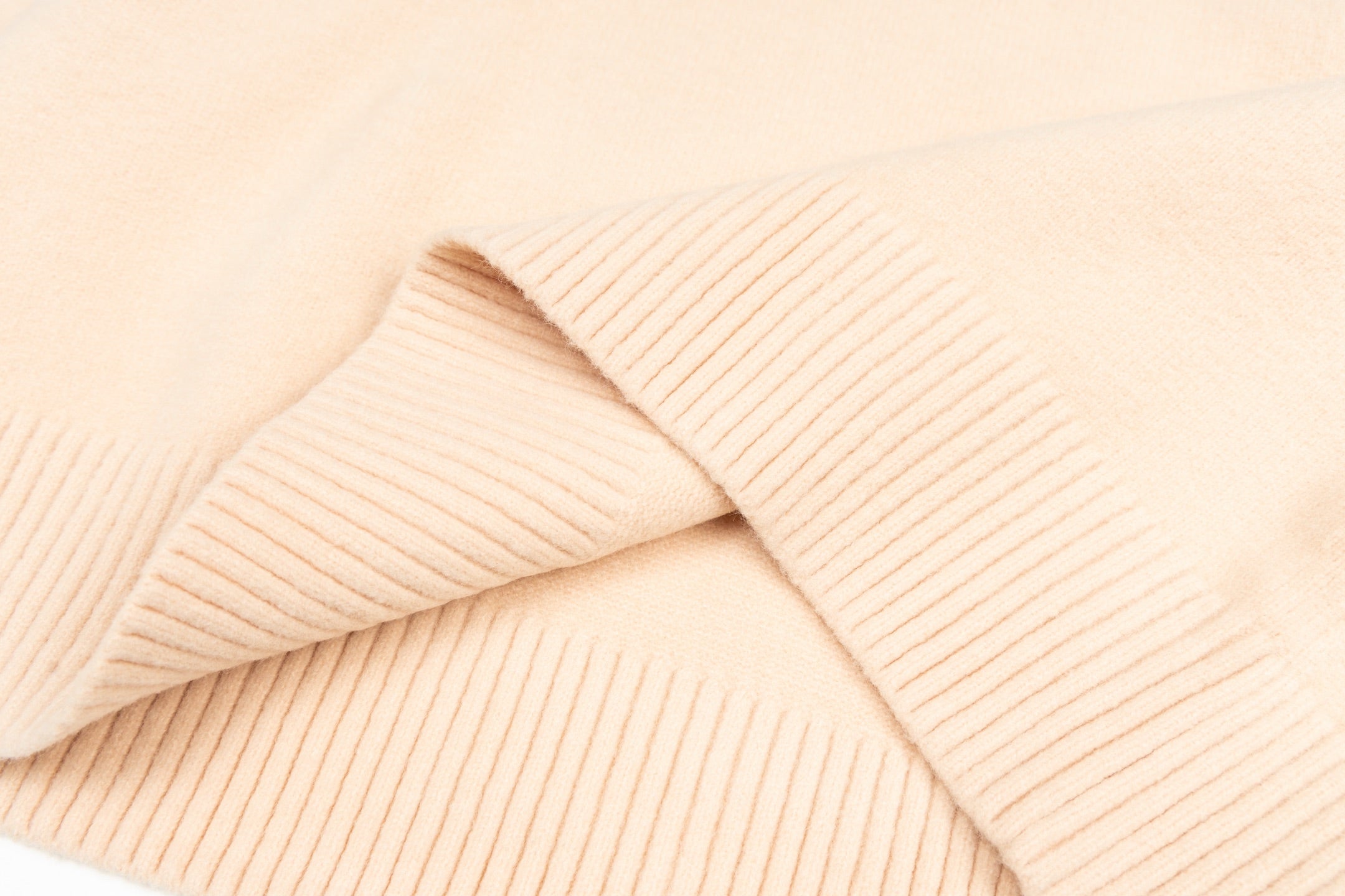 Light pink knit sweater with ribbed panel detailing near the shoulder