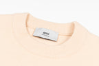 Light pink crewneck sweater neckline with ribbed collar and 'ami' label