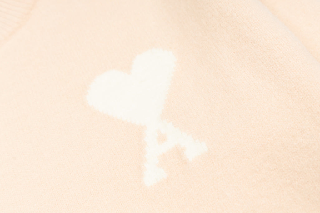 White heart-and-X motif on light pink sweater fabric