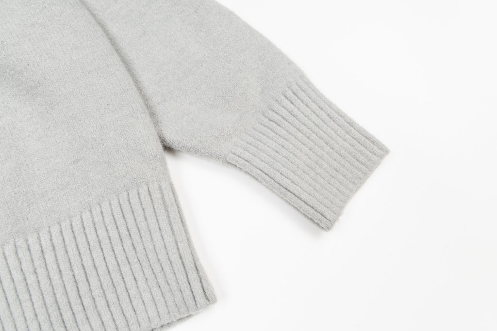 Amiri knit sweater close-up of ribbed hem and cuffs, light gray knit