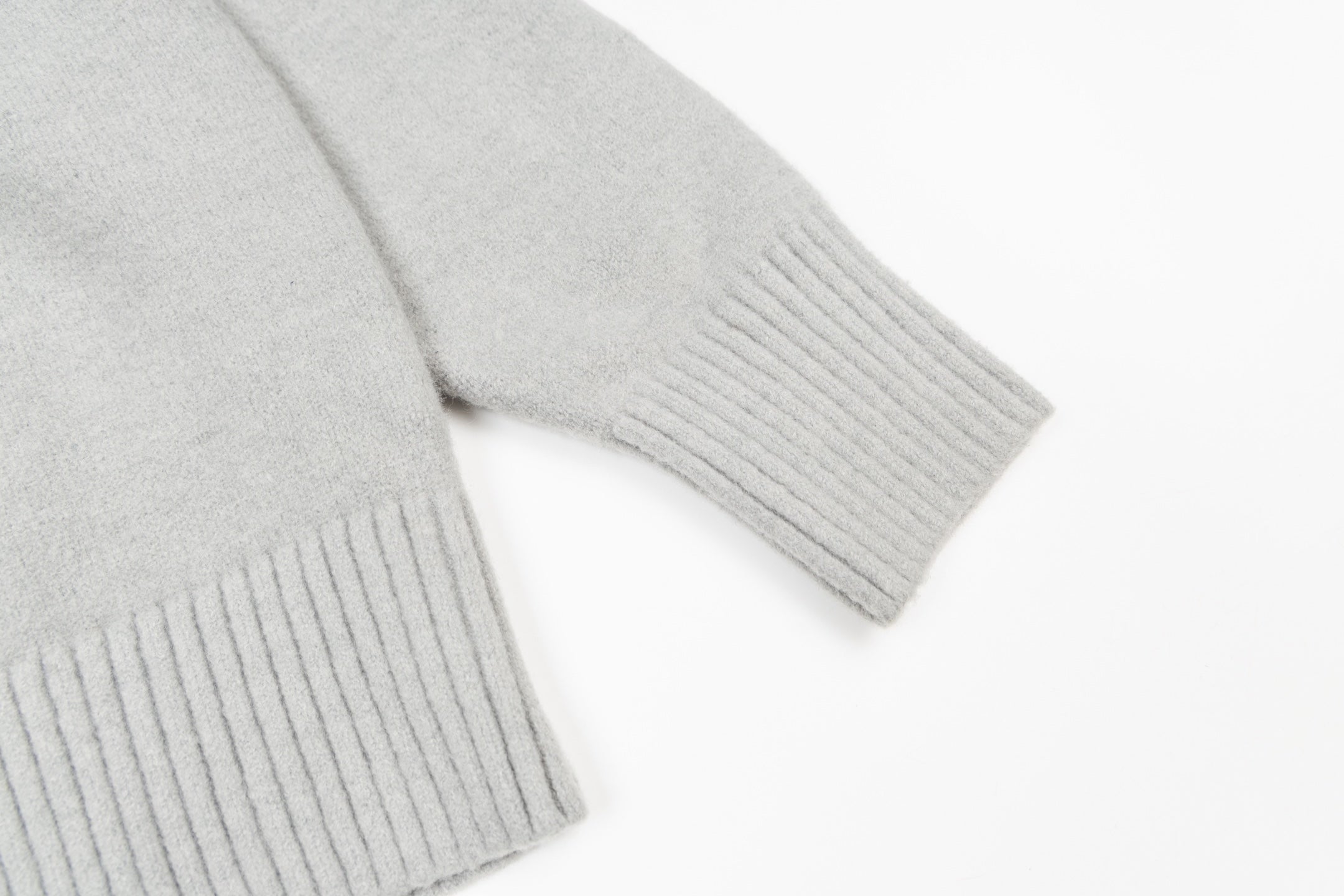 Amiri knit sweater close-up of ribbed hem and cuffs, light gray knit