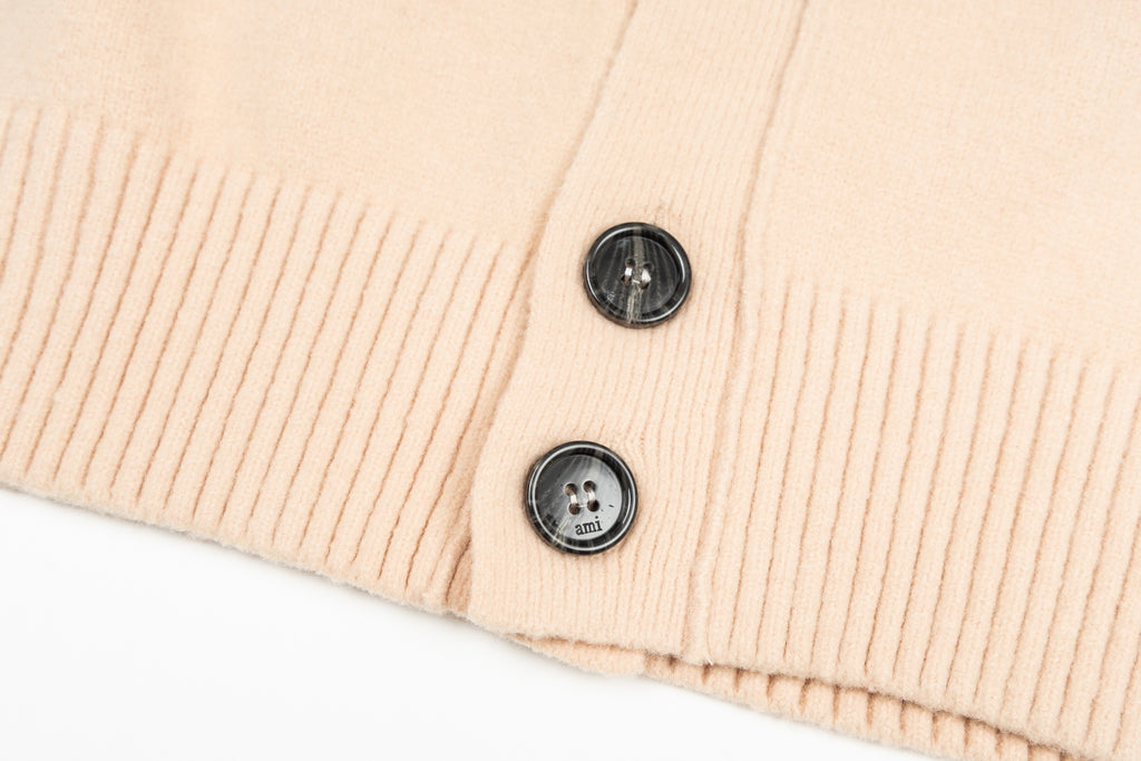 Amiri light peach cardigan hem with two black buttons and ribbed trim