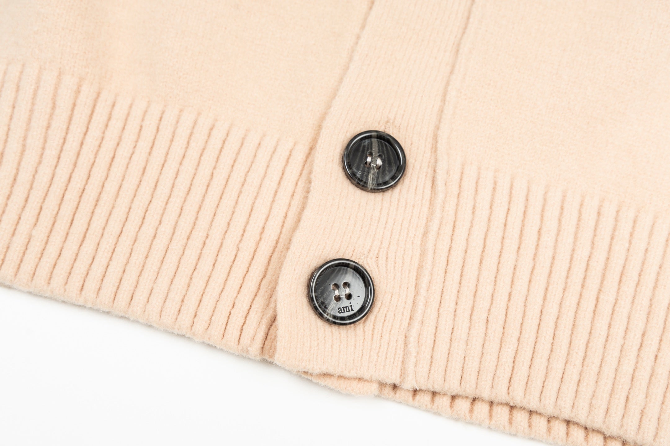 Amiri light peach cardigan hem with two black buttons and ribbed trim