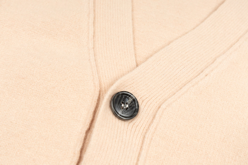 Amiri light peach knit cardigan with black button detail on button placket