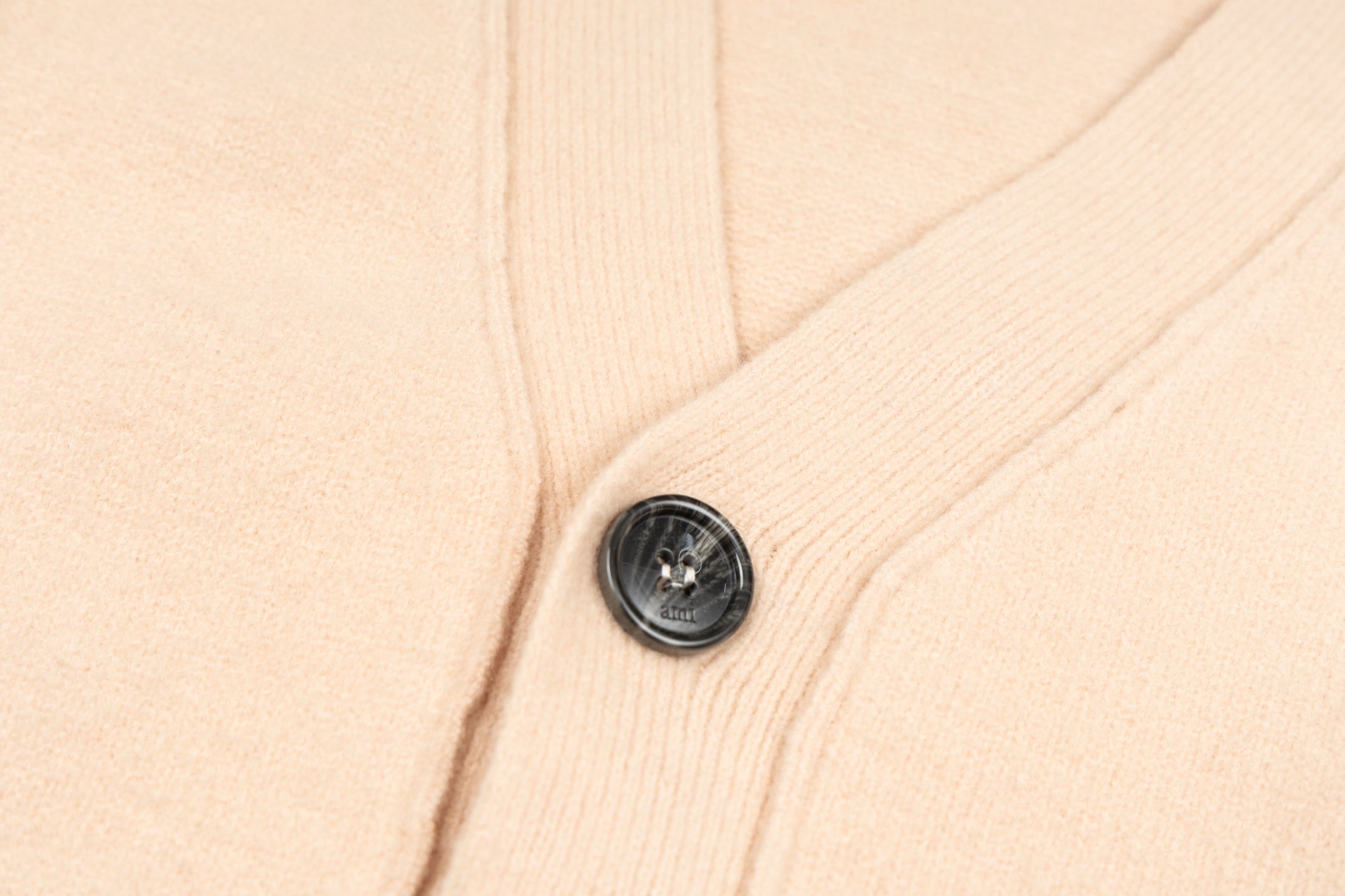Amiri light peach knit cardigan with black button detail on button placket