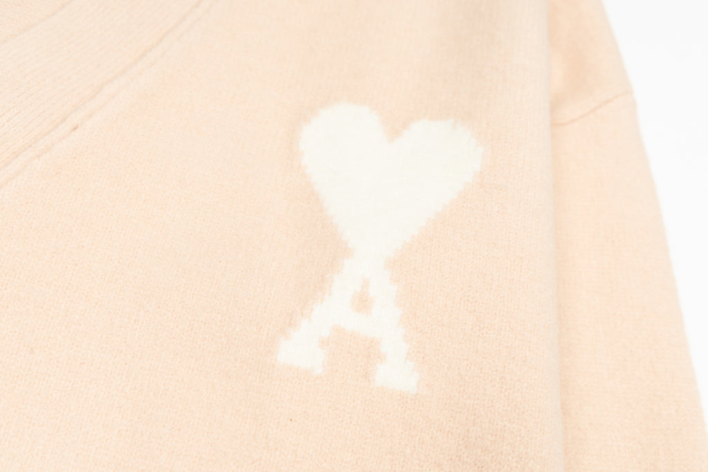 Amiri light peach cardigan with white heart logo motif on body
