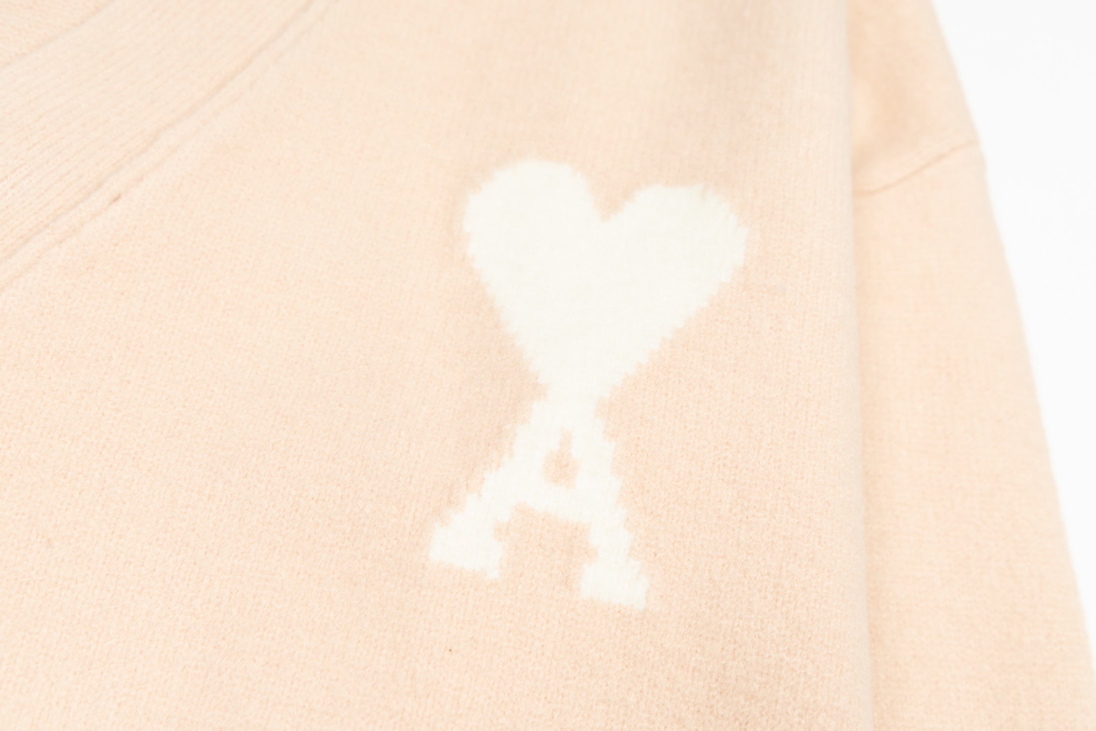 Amiri light peach cardigan with white heart logo motif on body