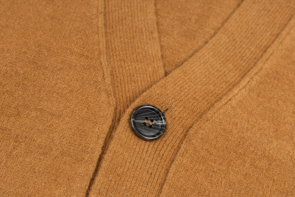 Tan knit cardigan with dark button and ribbed front placket