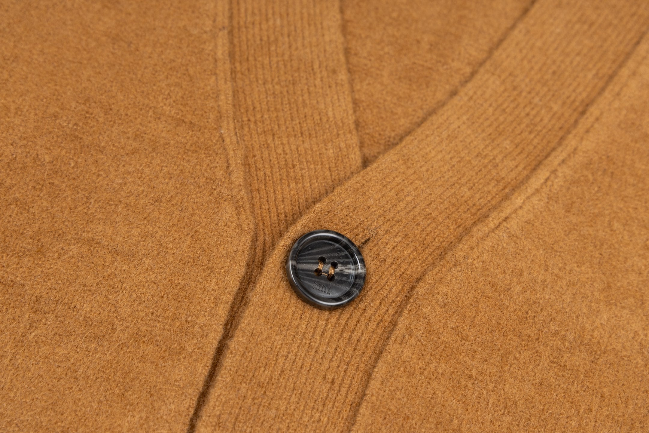 Tan knit cardigan with dark button and ribbed front placket