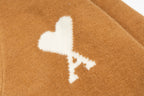 Tan knit cardigan with white logo emblem on chest