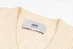 Cream knit sweater neckline with brand tag and V-neck ribbed collar