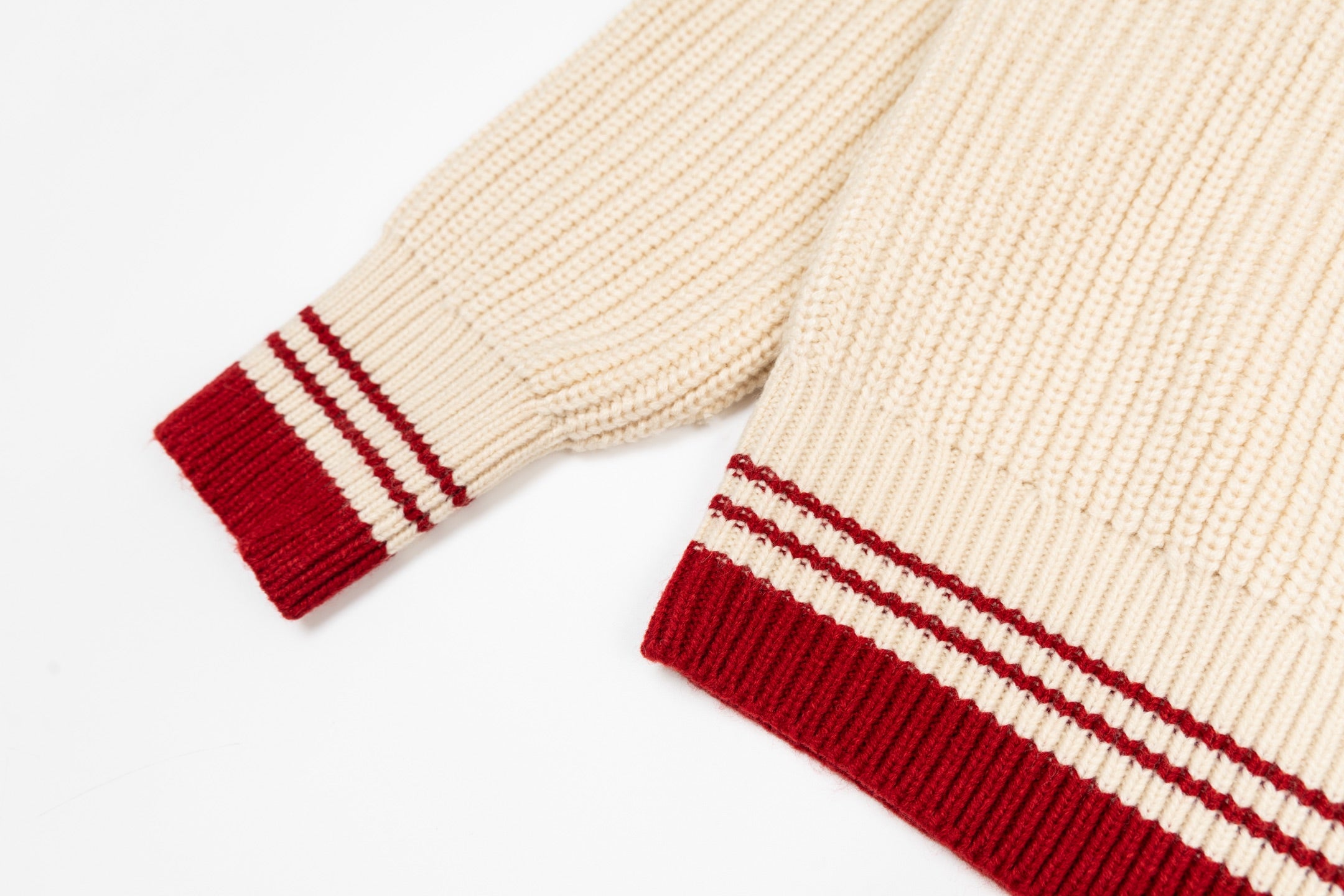 Cream sweater cuffs and hem with red-and-white striped ribbing