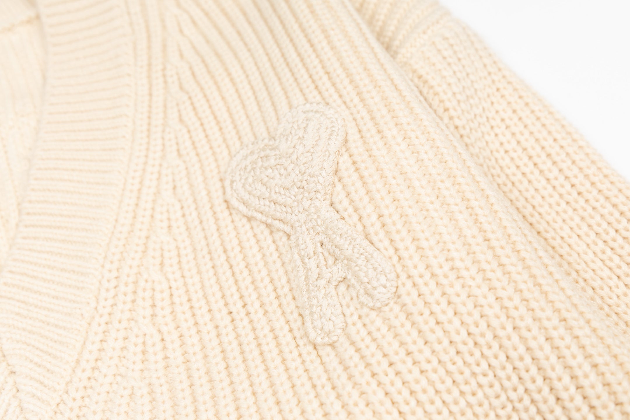 Cream knit sweater chest with raised embroidered floral script