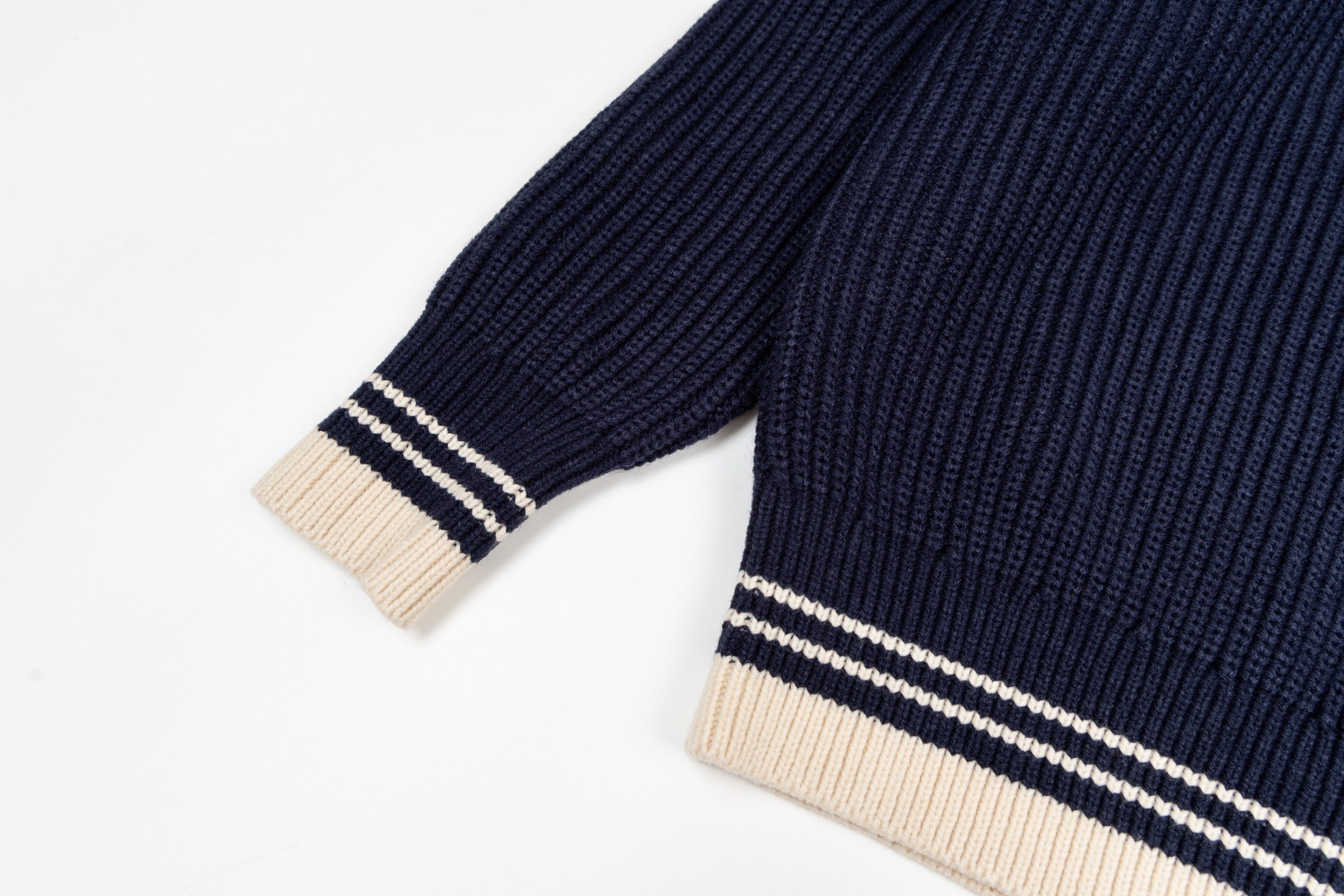 Navy knit sweater sleeve with striped ribbed cuff in cream and white
