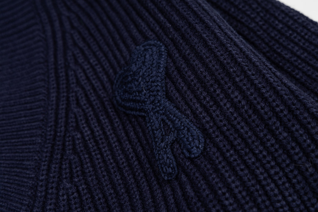 Navy ribbed knit sweater with raised embroidered graphic detail