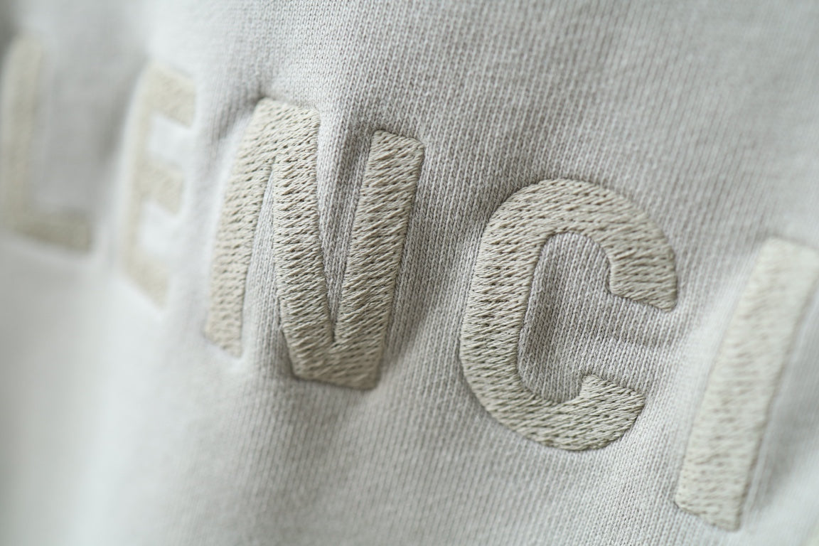 Embossed Balenciaga lettering on off-white hoodie fabric