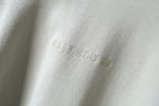 Close-up of embroidered Balenciaga logo on off-white hoodie fabric
