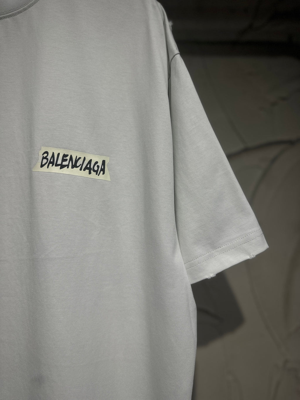White Balenciaga T-shirt side view with yellow patch-style chest logo