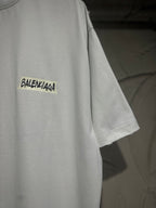 White Balenciaga T-shirt side view with yellow patch-style chest logo