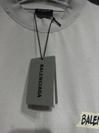 White Balenciaga T-shirt neckline close-up with hanging tag above logo
