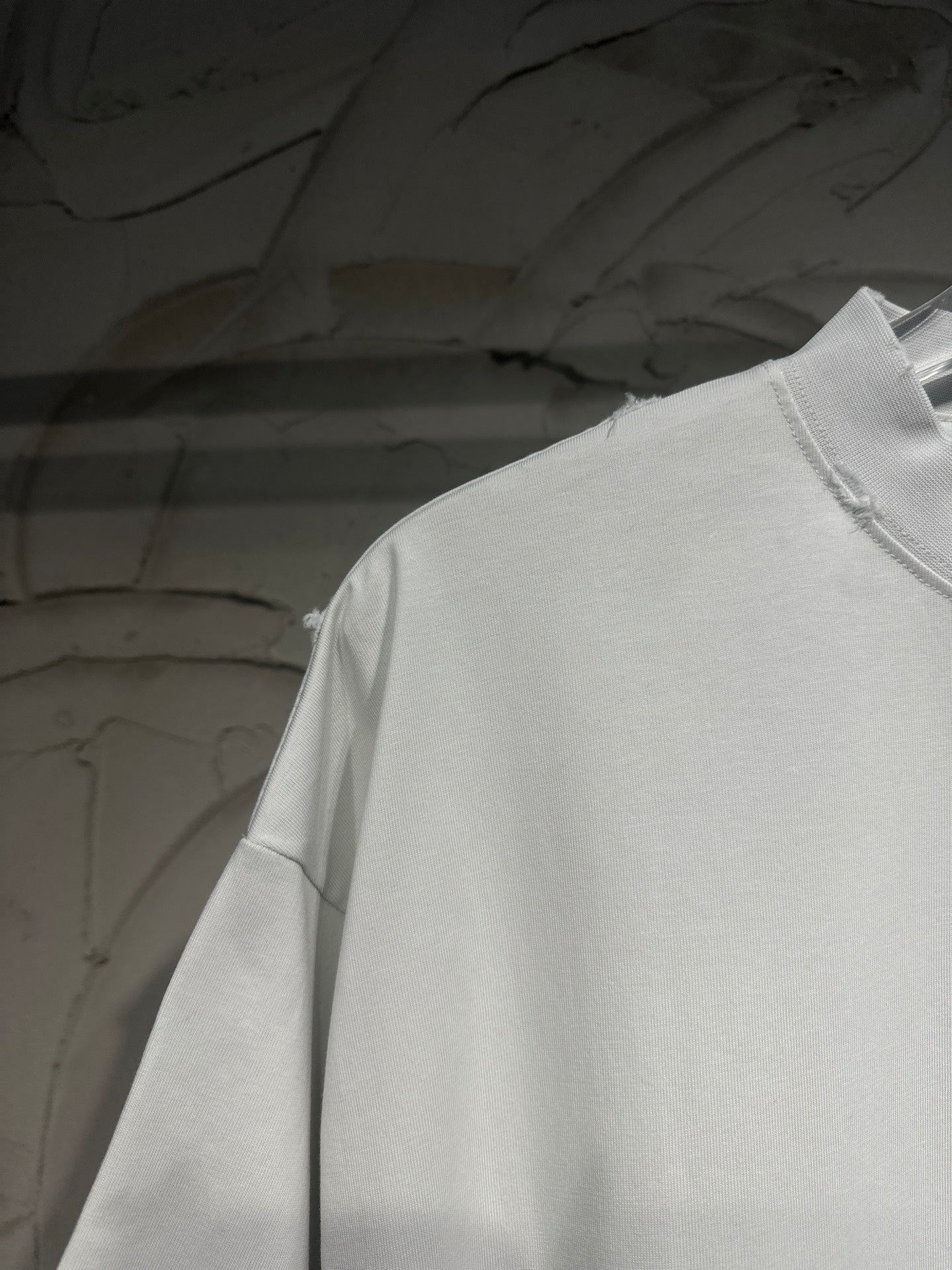 White Balenciaga T-shirt shoulder and upper sleeve in close-up