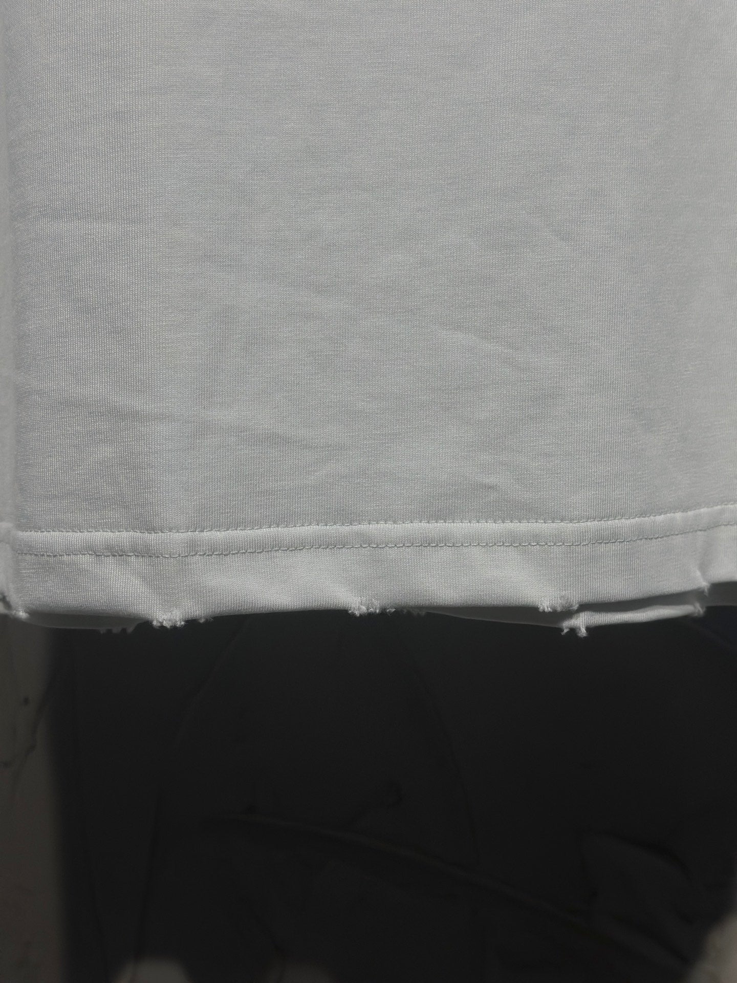 White Balenciaga T-shirt hem and bottom seam close-up